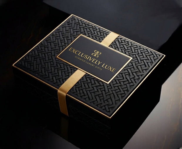 Black Exclusively Luxe gift box with a gold ribbon