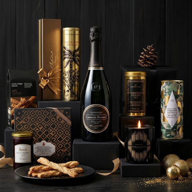 Christmas gift hamper with champagne, candles and gold-wrapped treats