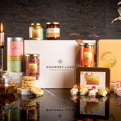 Elegant white hamper by Exclusively Luxe featuring dates, cookies, herbal tea, and gourmet jars