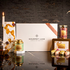 Elegant Exclusively Luxe white gift box with glass teapot, floral tea, dates, and dry fruits