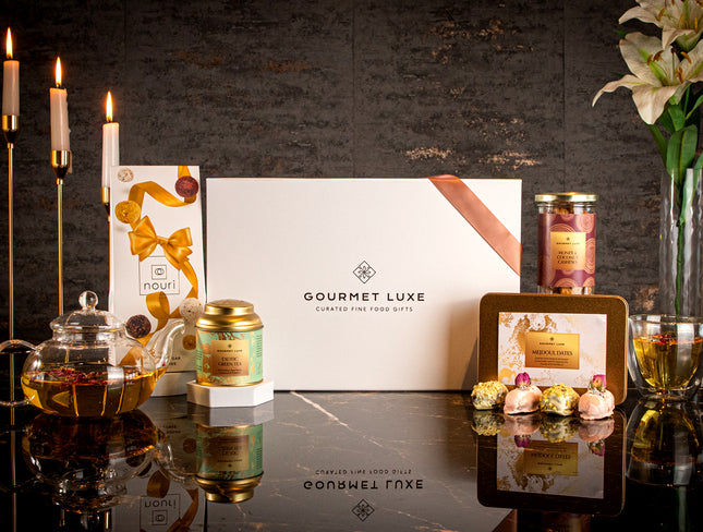 Elegant Exclusively Luxe white gift box with glass teapot, floral tea, dates, and dry fruits